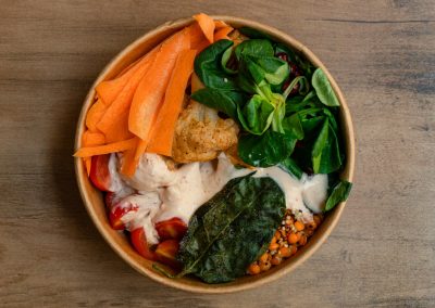 Draufsicht der veganen „Ma'Puaa Bowl“ von Bowls4 in Gera: Eine Schale gefüllt mit Quinoa, roten Linsen, Karotten, geröstetem Blumenkohl, Feldsalat, Kichererbsen und einem cremigen Tahini-Dip. Auch glutenfrei erhältlich.